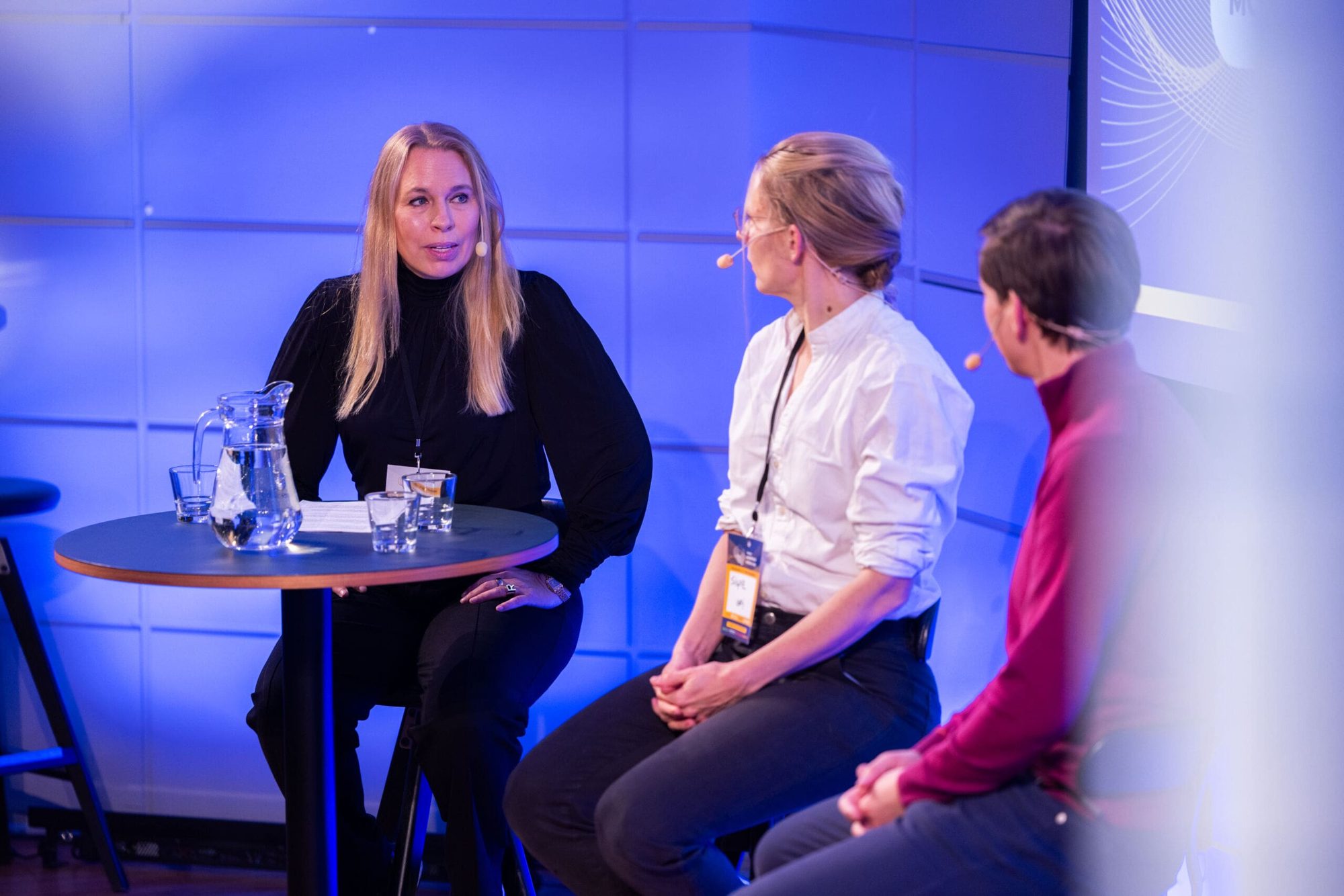 A roundtable group listens to a graphene presentation in a meeting room
