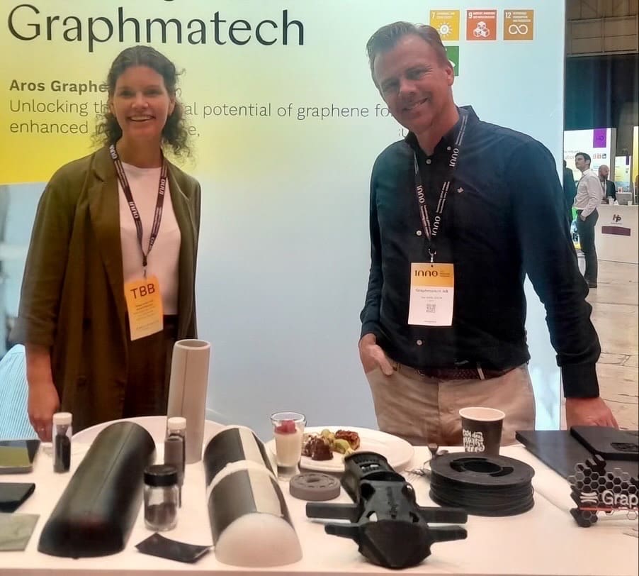 Two Graphmatech representatives behind a display of graphene material samples