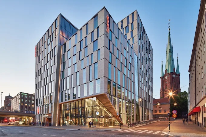 Scandic Continental's glass and stone exterior beside Klara Church in central Stockholm